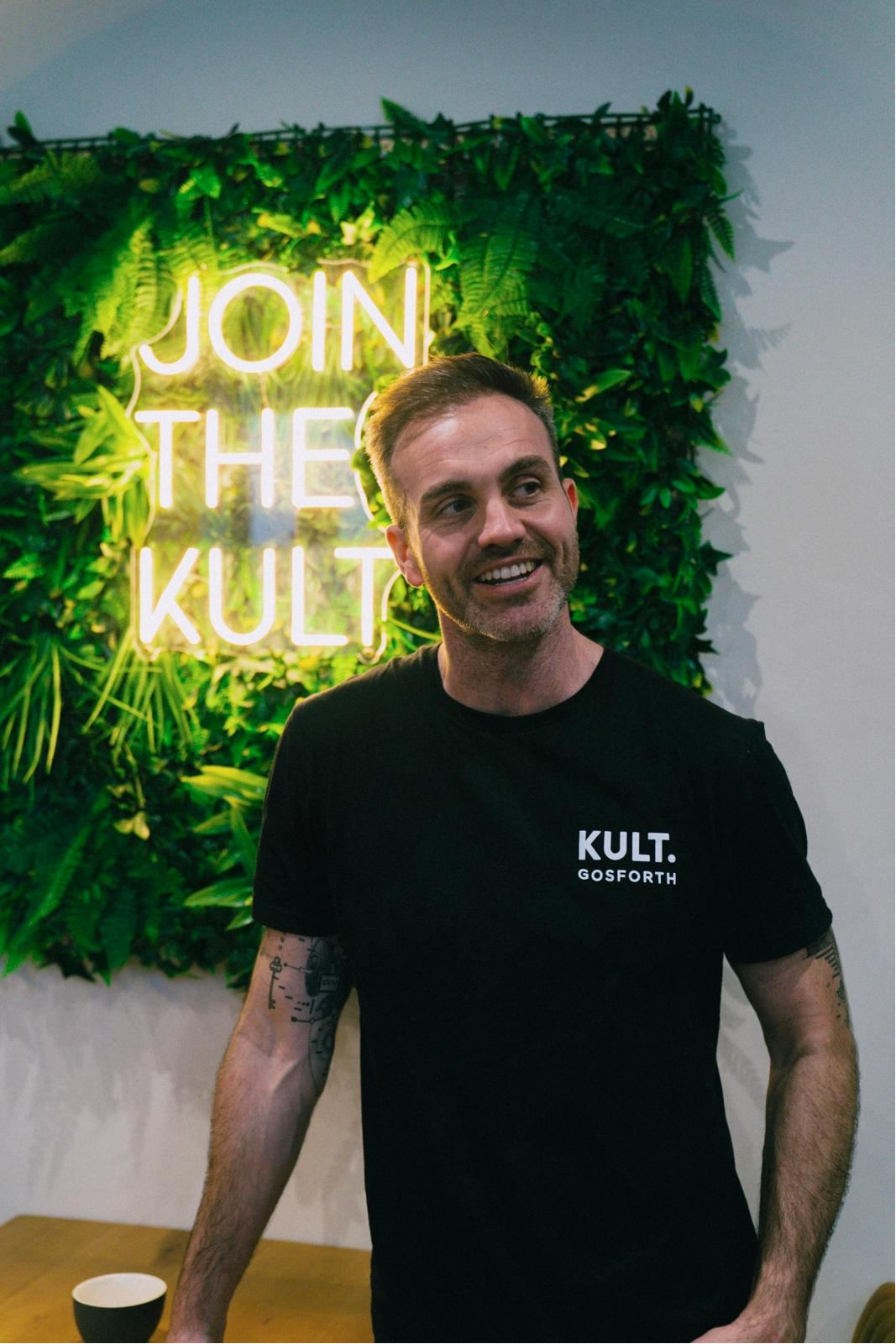 Mark Graham at KULT Gosforth, standing in front of the Join the KULT sign